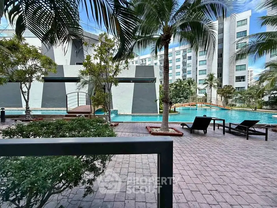 Luxurious poolside view with modern architecture and lush palm trees in a high-end residential complex.