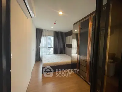 Modern bedroom with large window and sleek wardrobe in a stylish apartment.