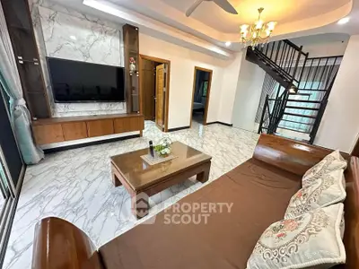 Elegant living room with marble flooring and stylish wooden furniture, featuring a modern TV setup and chandelier.