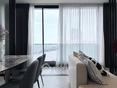 Modern living room with floor-to-ceiling windows offering stunning city and river views.