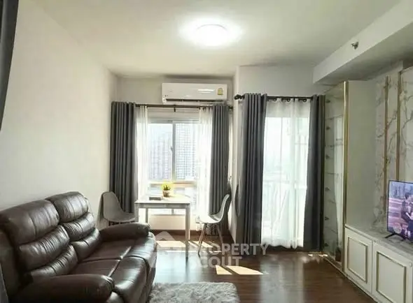 Bright living room with leather sofa and city view, perfect for relaxation.