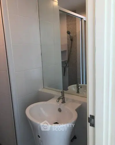 Compact bathroom with modern sink and shower in a cozy apartment.