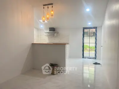 Modern kitchen with open layout and stylish lighting in a bright, newly renovated space.