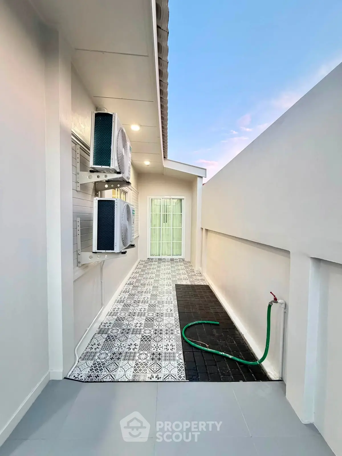 Modern outdoor space with stylish tiles and air conditioning units, perfect for urban living.