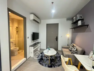 Modern living room with cozy seating and stylish decor in a compact apartment.