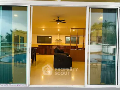 Spacious open-plan living room with pool view, modern kitchen, and elegant dining area.