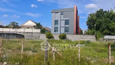 Modern building with lush greenery and clear blue sky, perfect for urban living.