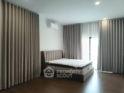 Spacious bedroom with modern design and large windows for natural light.