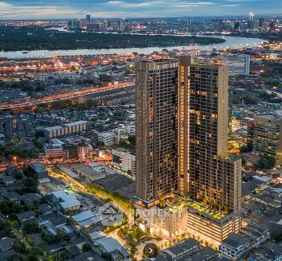 Stunning aerial view of modern high-rise building with cityscape and river in the background.