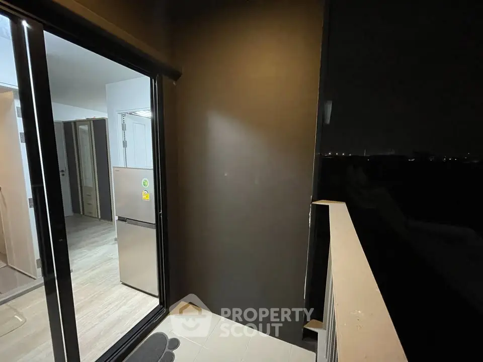 Cozy balcony with night view and sliding glass door to modern kitchen.