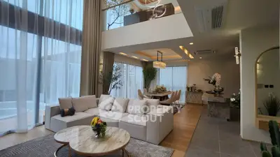 Luxurious open-plan living and dining area with elegant decor and floor-to-ceiling windows.