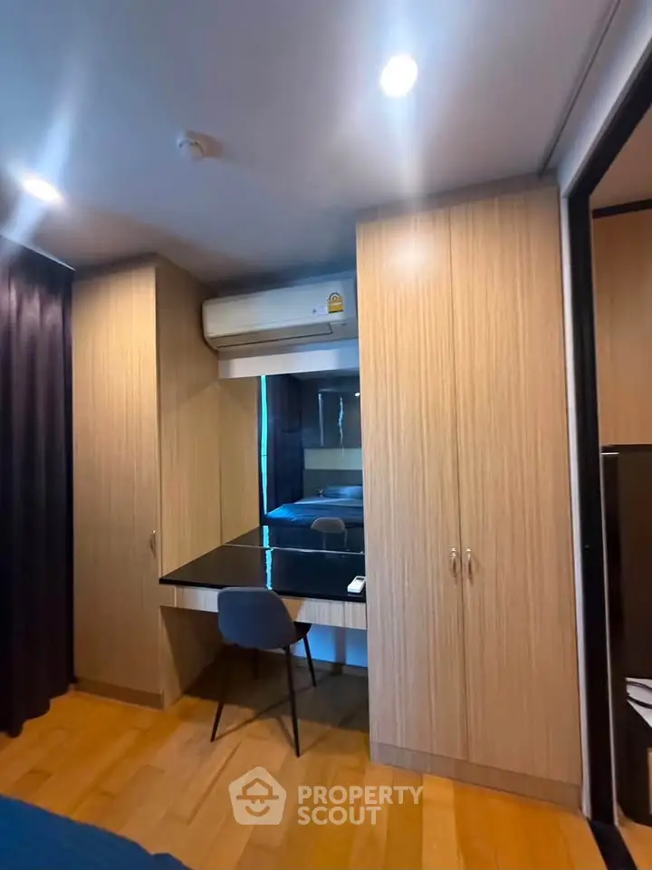 Modern bedroom with built-in wardrobe and sleek study area, perfect for urban living.