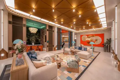 Luxurious living room with modern decor and vibrant artwork, featuring plush sofas and unique lighting.