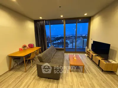 Modern living room with stunning city view, featuring sleek furniture and large windows for natural light.