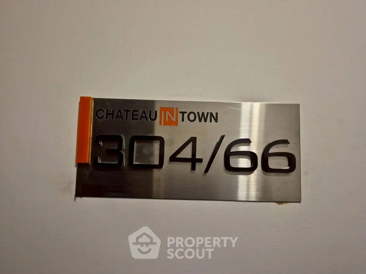 Chateau In Town unit number sign on a wall, sleek modern design.