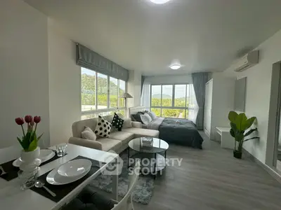 Modern studio apartment with open layout, featuring cozy living area and scenic views.