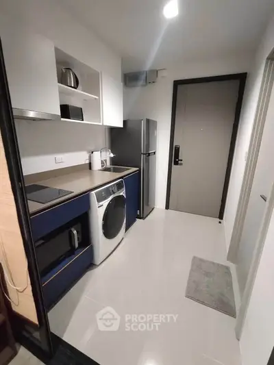 Modern kitchen with sleek appliances and stylish cabinetry in a compact layout.