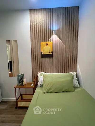 Cozy bedroom with modern decor and green bedding, perfect for relaxation.