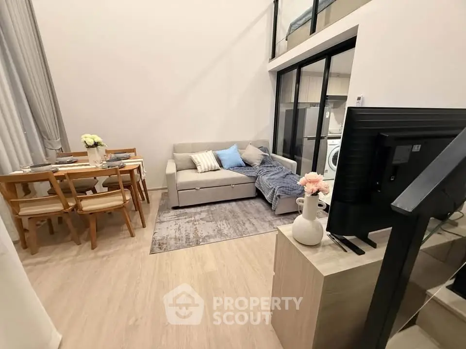 Modern living room with cozy sofa, dining area, and stylish decor in open-plan apartment.