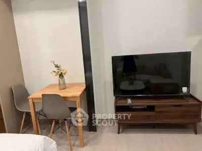 Modern living room with sleek TV stand and cozy dining area.