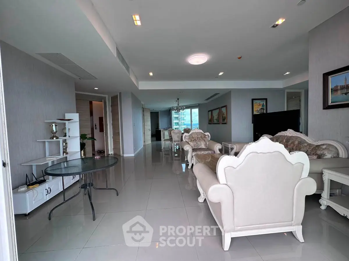 Spacious and elegant living room with luxurious furniture and large windows offering natural light.