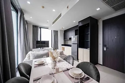 Modern open-plan living room and kitchen with elegant dining area and sleek appliances.