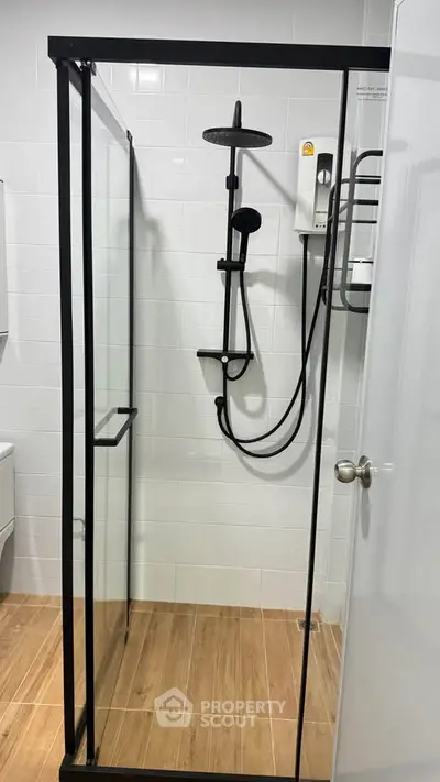 Modern bathroom with sleek glass shower enclosure and stylish fixtures.
