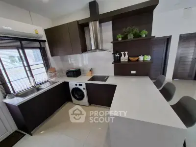 Modern kitchen with sleek cabinetry and built-in washing machine