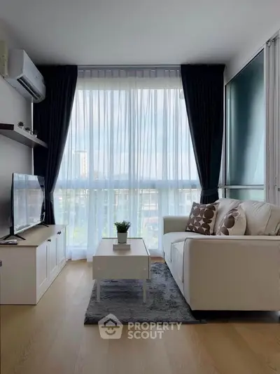 Modern living room with large window, cozy sofa, and stylish decor in a bright apartment.