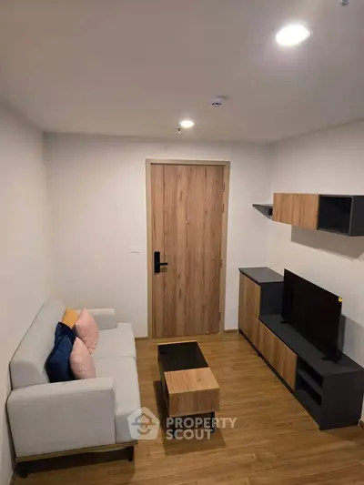 Modern living room with sleek furniture and wooden flooring, perfect for cozy relaxation.