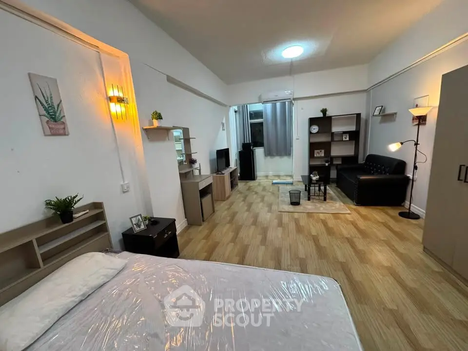 Spacious studio apartment with modern decor and open layout, featuring cozy living area and stylish furnishings.