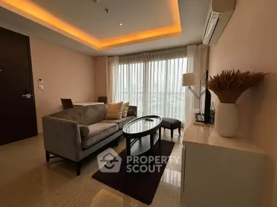 Modern living room with elegant furniture and large windows offering natural light.