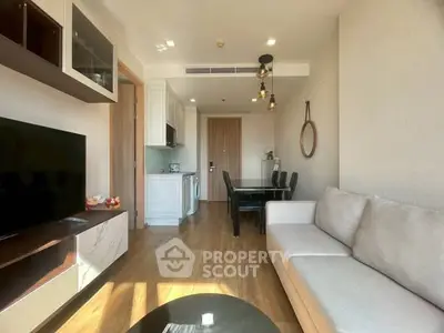 Modern living room with open kitchen, stylish decor, and natural light in a cozy apartment.
