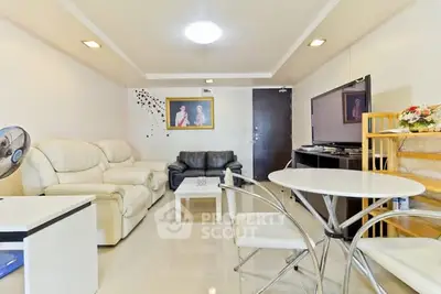 Modern living room with leather sofas and flat-screen TV, bright and inviting space.