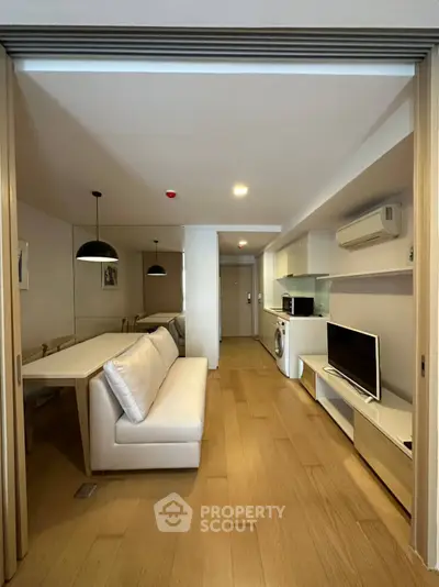 Modern living room with open layout, featuring sleek furniture and built-in appliances for a stylish urban lifestyle.