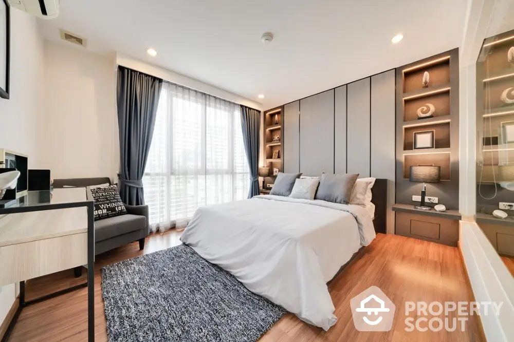 Modern bedroom with stylish decor, large window, and cozy ambiance in a luxury apartment.