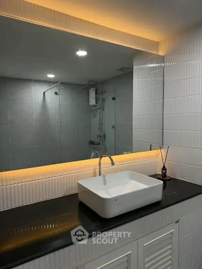 Modern bathroom with sleek sink and illuminated mirror