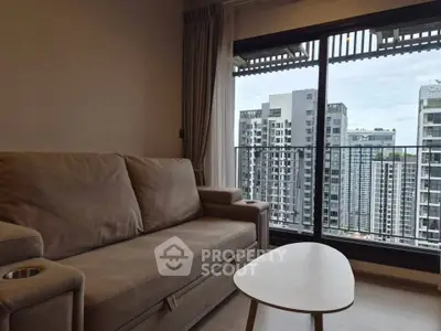 Modern living room with a cozy sofa and city view from the balcony, perfect for urban living.