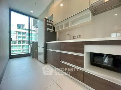 Modern kitchen with sleek cabinetry and appliances in a high-rise apartment.