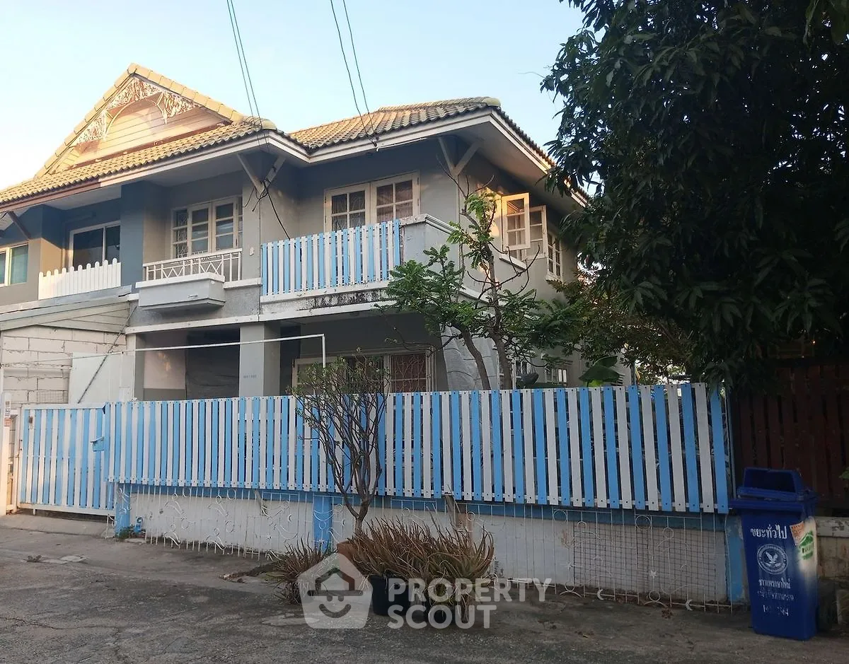 Charming two-story house with blue accents and a cozy balcony, perfect for family living.