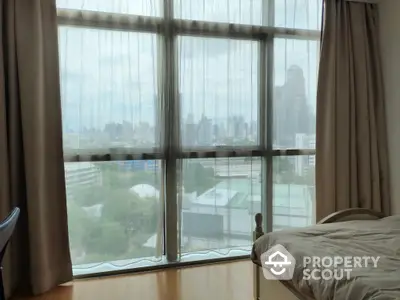 Spacious bedroom with stunning city view through large windows