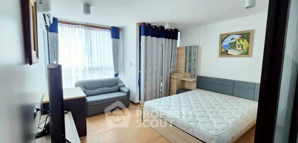 Bright and cozy bedroom with modern furnishings and large window for natural light.