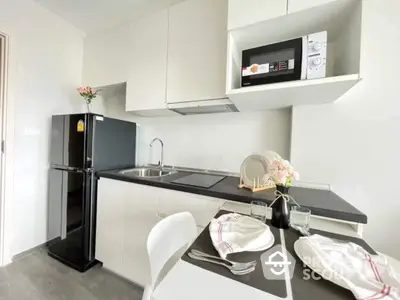 Sleek modern kitchen with black countertops, white cabinetry, and state-of-the-art appliances, perfect for culinary enthusiasts.