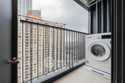 Modern balcony with washing machine and city view in high-rise apartment