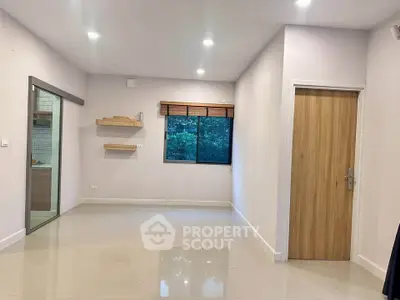 Spacious unfurnished room with modern lighting and large window view.