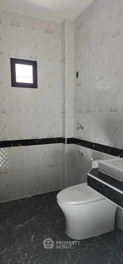 Modern bathroom with sleek gray tiles and contemporary fixtures.