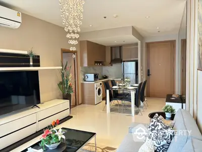 Modern living room with open kitchen, stylish decor, and dining area in a cozy apartment.