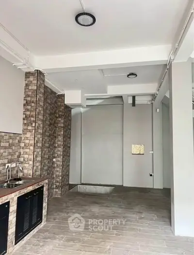 Modern kitchen with sleek design and open layout, featuring stylish brick accents and contemporary fixtures.