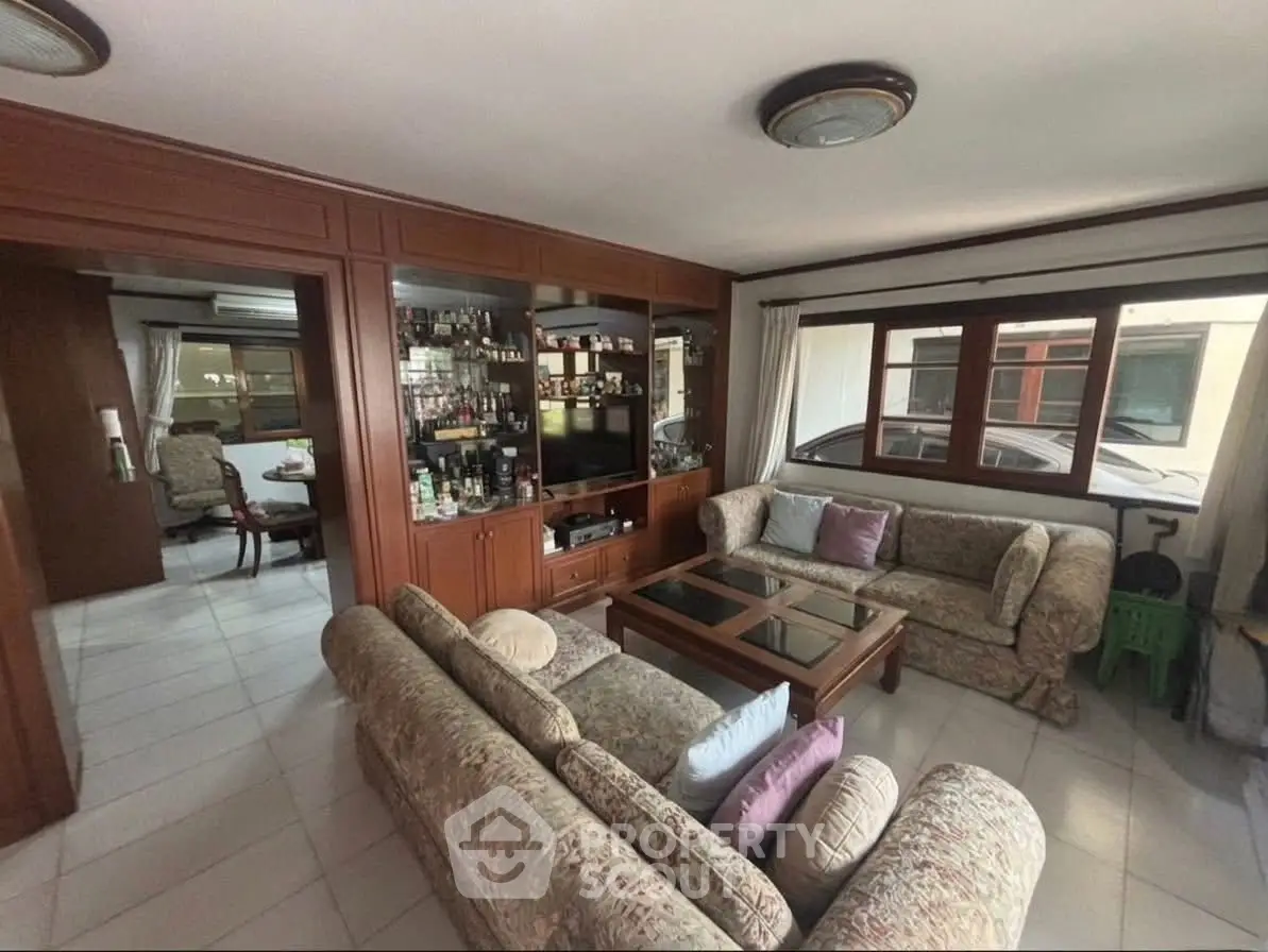 Spacious living room with elegant wooden cabinetry and cozy seating area, perfect for family gatherings.