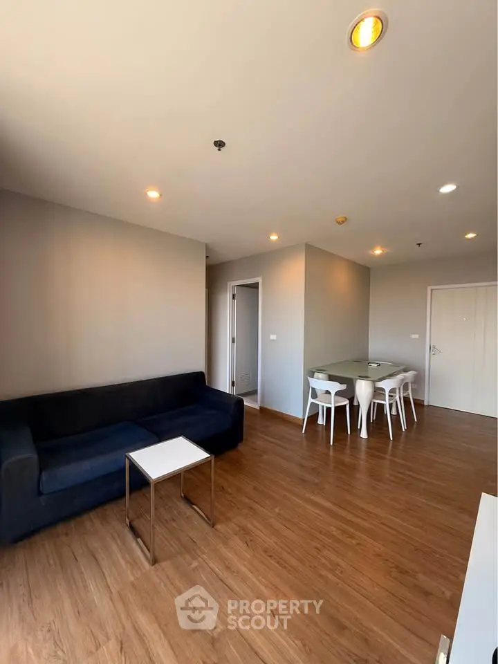 Modern living room with sleek furniture and wooden flooring in a stylish apartment.